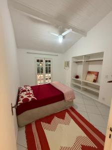 a bedroom with a bed with a red blanket at Casa Praiana Búzios in Búzios +19 photos