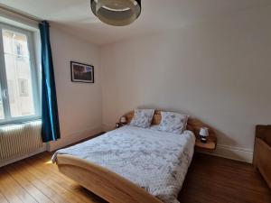 a bedroom with a bed and a large window at Gîte Comme Chez Vous à Lunéville confort, calme et séjour en Lorraine in Lunéville