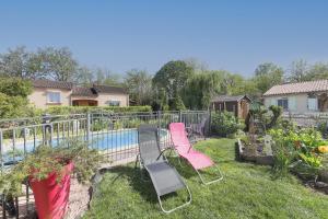 a yard with two chairs and a swimming pool at Gite la Provençale in Albi
