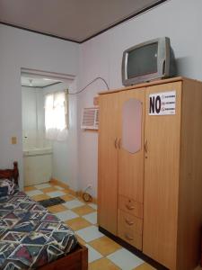 a bedroom with a tv on top of a wooden cabinet at Felipenas Lodging House in Matalom +18 photos