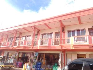 a pink building with a balcony on top of it at Felipenas Lodging House in Matalom