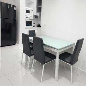 a dining room table with four chairs and a refrigerator at Angelic stay in Hulhumale