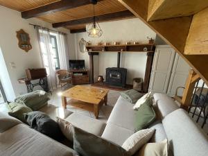 a living room with a couch and a table at Gite linstant rêvé in Labesserette