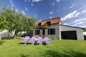 a group of purple chairs sitting in the grass at Gite linstant rêvé in Labesserette