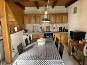 a kitchen with a table with chairs and a sink at Gite linstant rêvé in Labesserette
