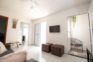 a living room with a couch and a tv on a wall at Jahu Center Casas Un 2 in Jaú