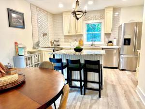 a kitchen with a wooden table and a kitchen island at HPThe Bungalow Spectrum Bojangles Fenced Yard Dog in Charlotte