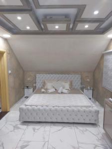 a large white bed in a room with marble floors at Jacuzzy Rooms Andjela in Subotica