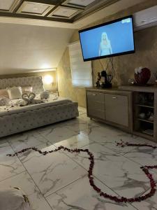 a living room with a bed and a flat screen tv at Jacuzzy Rooms Andjela in Subotica