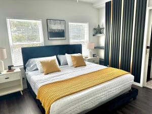 a bedroom with a large bed with a blue headboard at HPThe Abode Downtown Bojangles Dogs Welcome Yard in Charlotte