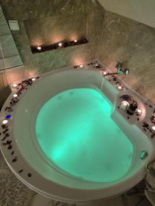 a bathroom with a blue tub with lights in it at Jacuzzy Rooms Andjela in Subotica