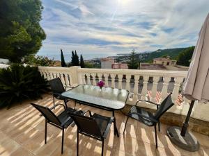 a patio with a table and chairs on a balcony at Chalet con piscina y vistas en Urb Marcolina, Alcocéber in Alcossebre