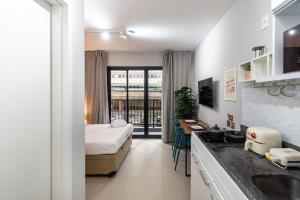 a hotel room with a bed and a kitchen at Studio with Pool and Gym - DP203 in São Paulo