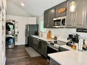 a kitchen with stainless steel appliances and wooden floors at HPThe Abode Downtown Bojangles Dogs Welcome Yard in Charlotte