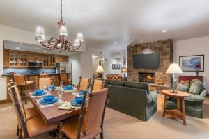 a dining room and living room with a table and a fireplace at Teton Club in Teton Village
