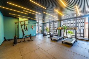 a gym with cardio equipment in a building with windows at Studio with Pool and Gym - DP203 in São Paulo