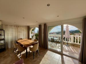 a dining room with a table and a balcony at Chalet con piscina y vistas en Urb Marcolina, Alcocéber in Alcossebre