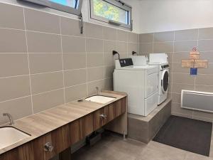 a laundry room with a washing machine and a sink at ZEcamping 3 étoiles vue exceptionnelle et soirées animées in Gex +7 photos