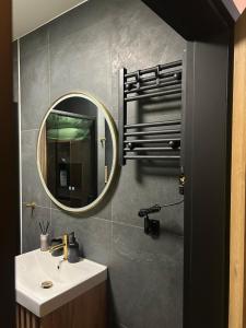 a bathroom with a sink and a mirror at Apartament Bond in Szczawno-Zdrój +9 photos