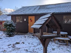 a log cabin in the snow with a bird feeder at Chalet HEUREux in Somme-Leuze