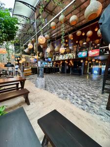 a restaurant with benches and tables in front of a bar at Paragon mirissa by REO in Mirissa