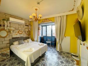 a bedroom with a bed and a yellow wall at Lamur Hotel in Alaçatı