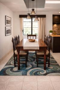 a dining room with a table and chairs on a rug at Nadi Airport Bed & Breakfast in Nadi