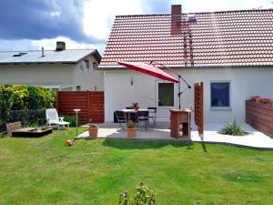 eine Terrasse mit einem Tisch und einem Sonnenschirm im Hof in der Unterkunft Ferienwohnung im Wiesengrund in Stahlbrode