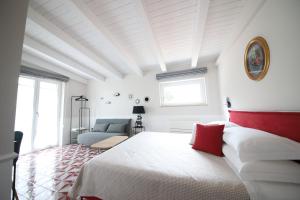 a white bedroom with a bed and a couch at Tenuta Bellelli in Castellabate