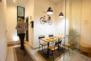 a man walking into a room with a table and a bike on the wall at Zalamera BnB in Valencia