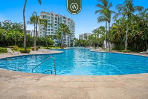 a swimming pool at a resort with palm trees at New 2BR/2BA Nuevo Vallarta Condo | Pool, Beach in Nuevo Vallarta
