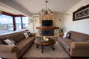 a living room with two couches and a fireplace at Royal stylish view apartment in Koropi