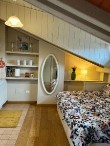 a bedroom with a bed and a round mirror at La casa sui tetti di Varzi in Varzi