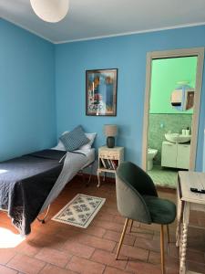 a bedroom with blue walls and a bed and a chair at La casa sui tetti di Varzi in Varzi