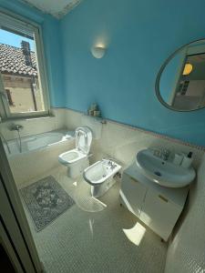 a bathroom with a sink and a toilet and a tub at La casa sui tetti di Varzi in Varzi