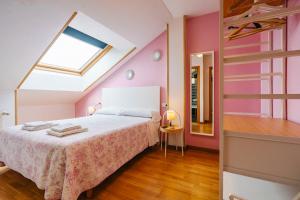 a bedroom with a bed with pink walls and a window at adrimarcangas in Cangas de Onís