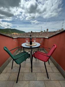 a table and chairs on a balcony with a bottle of wine at La casa sui tetti di Varzi in Varzi