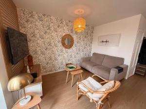 a living room with a couch and a tv at le macareux in Perros-Guirec