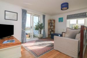 a living room with a flat screen tv and a couch at 4 The Elms in Salcombe