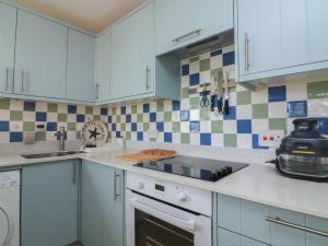 a kitchen with white cabinets and a stove top oven at 4 The Elms in Salcombe