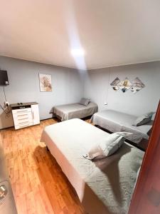a bedroom with two beds and a desk in it at Hotel Boutique Casa Piedra in Tocopilla