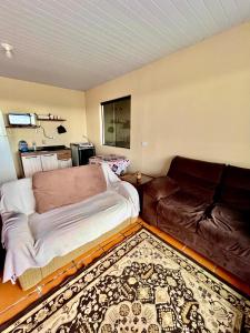 a living room with a bed and a couch at Casa Beira Mar in Matinhos +3 photos