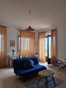 a living room with a blue couch and a table at NoiSalento in Marina di Mancaversa
