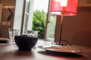 un tavolo con una piastra, una lampada e dei bicchieri di Le Logis de Céline a Cajarc