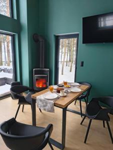a room with a table and chairs and a fireplace at Cieniówka, dom w lesie, Kije in Kije