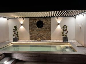 a swimming pool in a room with a brick wall at Mini Villa d'Exception avec Piscine Jacuzzi Sauna et Home Cinema Privés in La Baule