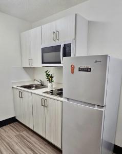 a kitchen with a refrigerator and a microwave at Siegel Select Orange Park in Orange Park