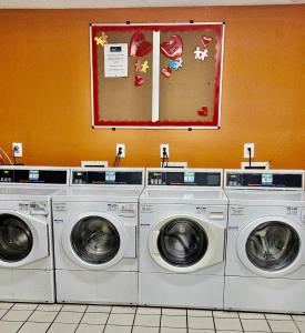three washing machines in a laundry room with a picture on the wall at Siegel Select Orange Park in Orange Park