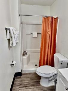 an orange shower curtain in a bathroom with a toilet at Siegel Select Orange Park in Orange Park +13 photos