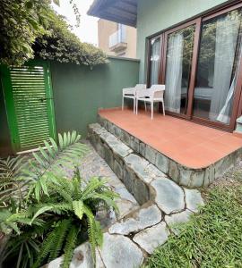 a patio with two chairs on a house at Lush Garden Chalet in Afiaman